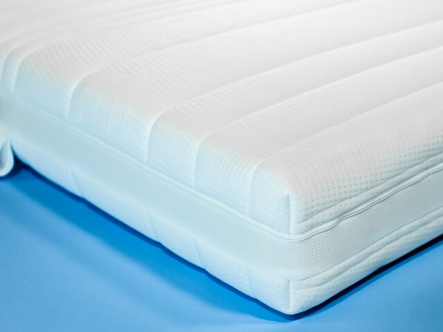 Nahansicht der Taschenfederkernmatratze Orthoganic Klimapaket auf blauem Hintergrund