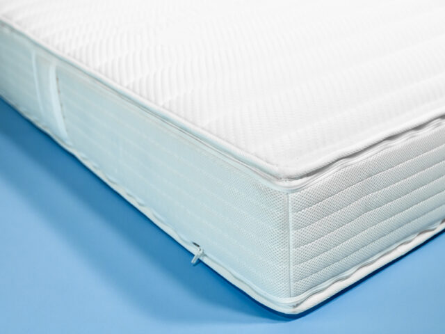 Nahansicht der Taschenfederkernmatratze Orthoganic Heavy Metal auf blauem Hintergrund