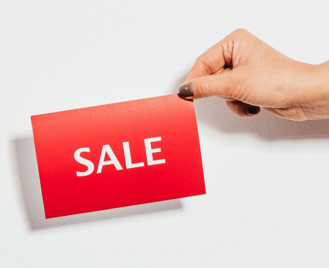 Schild in der Hand mit Aufschrift Sale